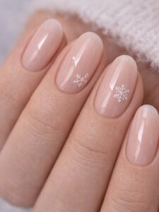 Minimal winter nails with glossy sheer nude pink and tiny white snowflake accents, short almond shape, San Diego nail salon